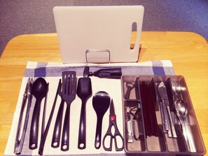 A table with a laptop, a set of black utensils, and a pair of scissors on a checkered cloth. - Condominium Sunset Inn (Hakuba)