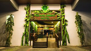 The entrance of the Grand Orient Hotel with a wooden sign, steps, and green plant decorations. - Grand Orient Hotel Perai (Perai)