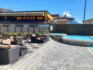 An outdoor patio with wicker furniture and a pool. - Hotel Camping Europa (Domaso)