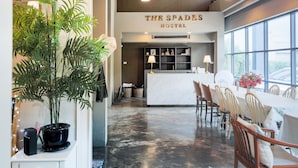 A modern hotel lobby with a reception desk, seating area, and large windows offering views. - Collection O The Spades Hostel (Bangkok)