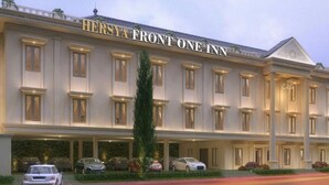 Un grande hotel a più piani con uno stile architettonico classico, con un cartello ben visibile che recita "Hersya Front One Inn".