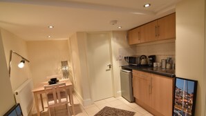 A compact kitchen with wooden cabinets, a microwave, and a dishwasher. - Brighter Properties (London)