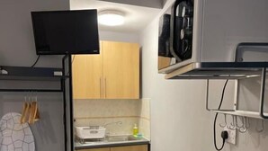 A compact kitchen with a microwave, toaster, kettle, and a small sink. - Brighter Properties (London)