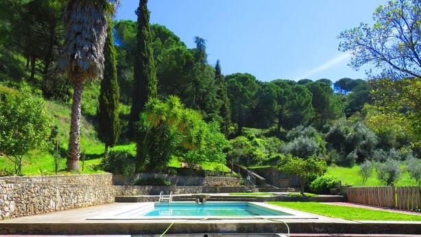 A stone pool with a stone fountain, surrounded by a stone wall and lush greenery. - Quinta de Rio Alcaide (Porto de Mos)