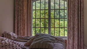 A room with a large window, curtains, and a bed with a blanket and pillows. - Quinta de Rio Alcaide (Porto de Mos)