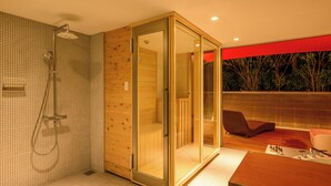 Et moderne badeværelse med bruser, et glasafskærmet walk-in closet og trægulv.