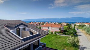 A residential area with houses, a road, and a view of the sea and mountains. - Asil Apart Otel (Burhaniye)