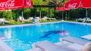 Outdoor pool, a waterfall pool, pool umbrellas, pool loungers