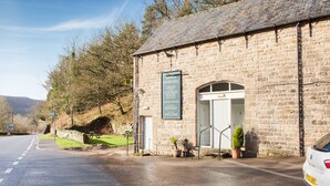 A stone building with a signboard indicating it is a restaurant. - Ladybower Inn (Hope Valley)