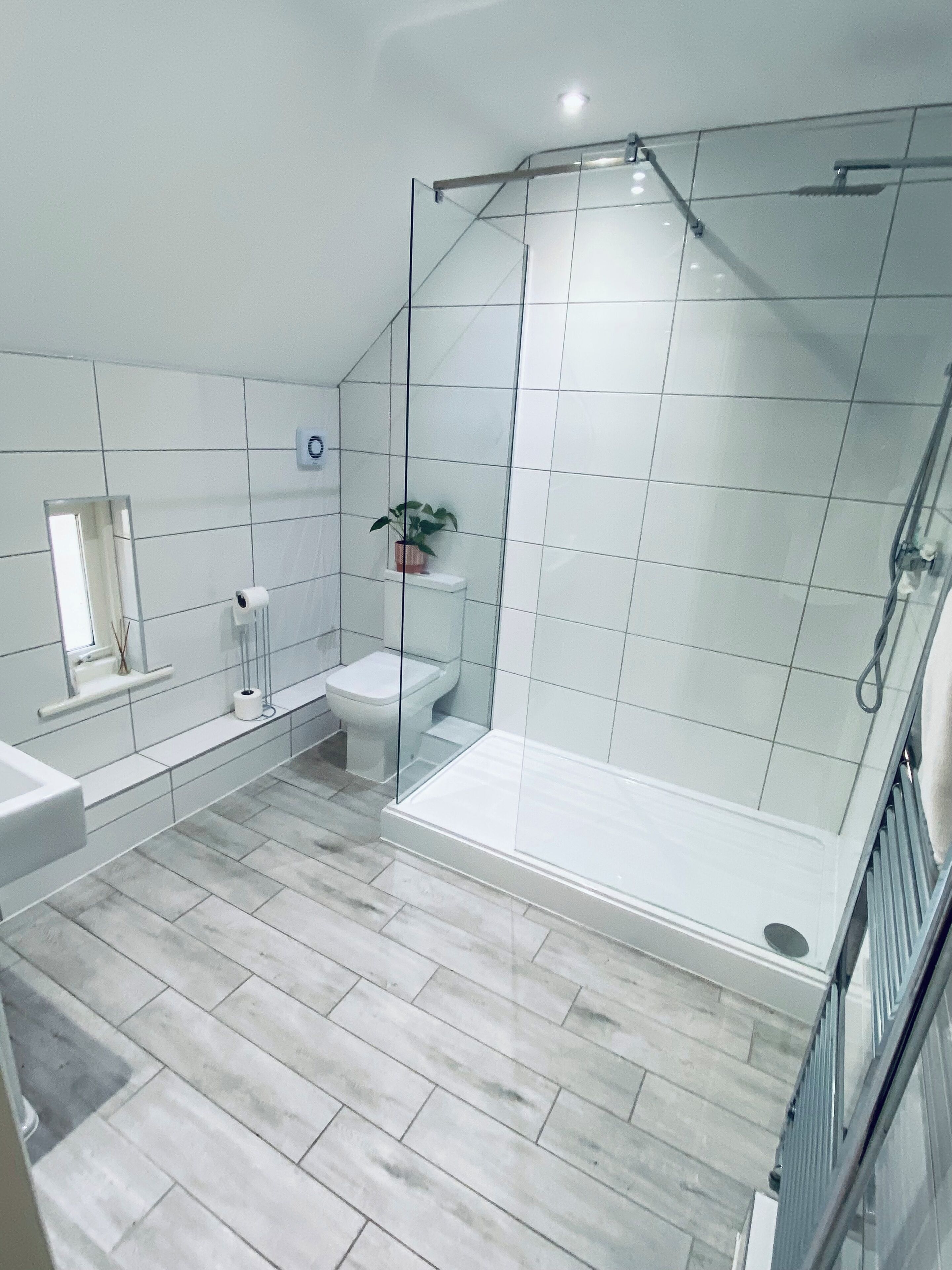 Un baño moderno con cabina de ducha de vidrio, inodoro y lavamanos.