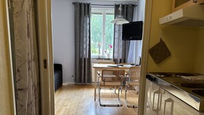Una cocina con comedor, piso de madera y vista al exterior.