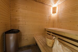 A wooden sauna with benches, a bucket, and a trash can. - Brålanda Hotell & Vandrarhem - Hostel (Bralanda)