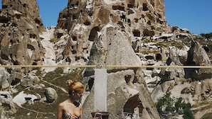 A woman sitting by a pool with a rocky mountain backdrop. - Hermes Cave Hotel (Nevsehir)