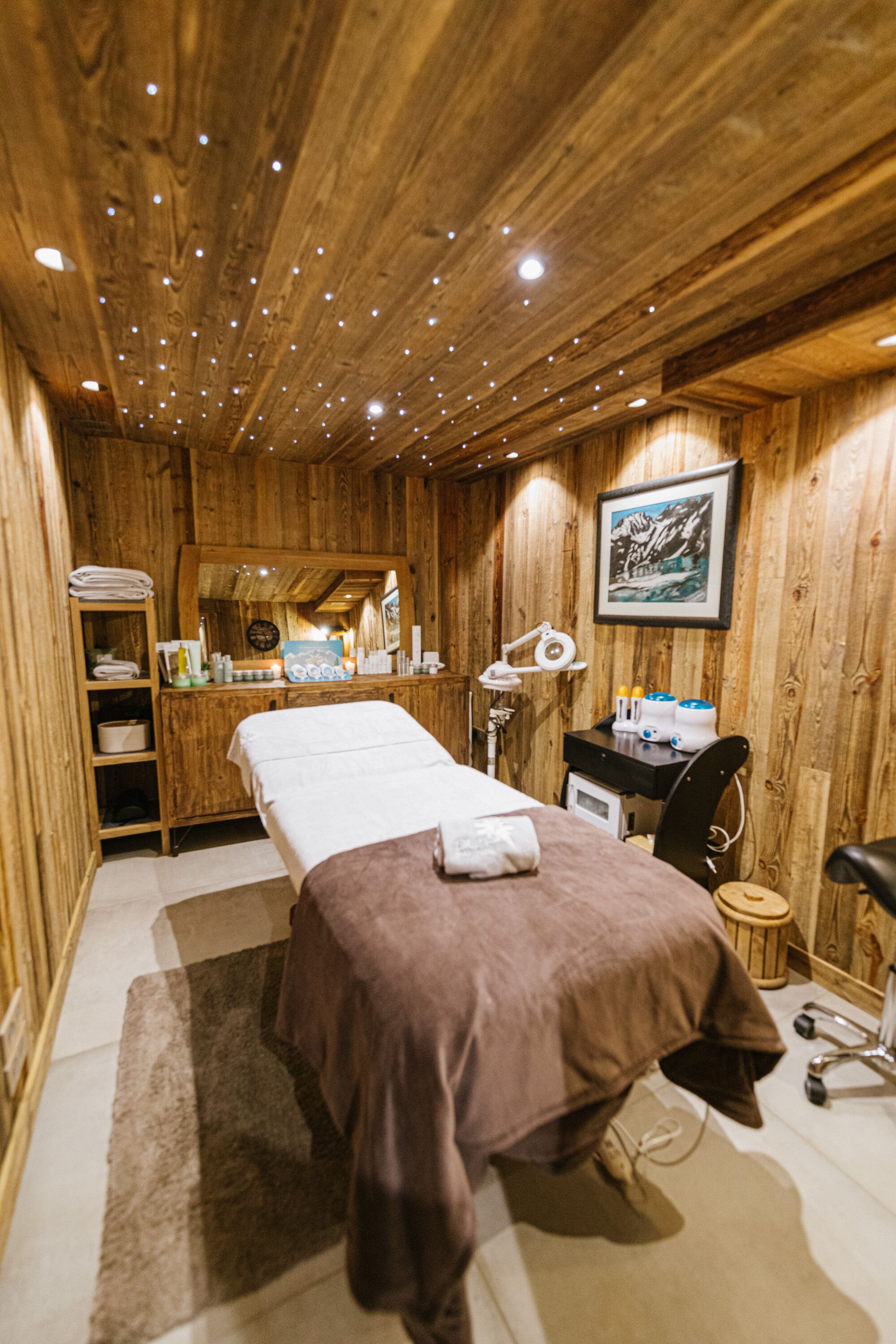 A wooden room with a bed, a desk, and a chair.