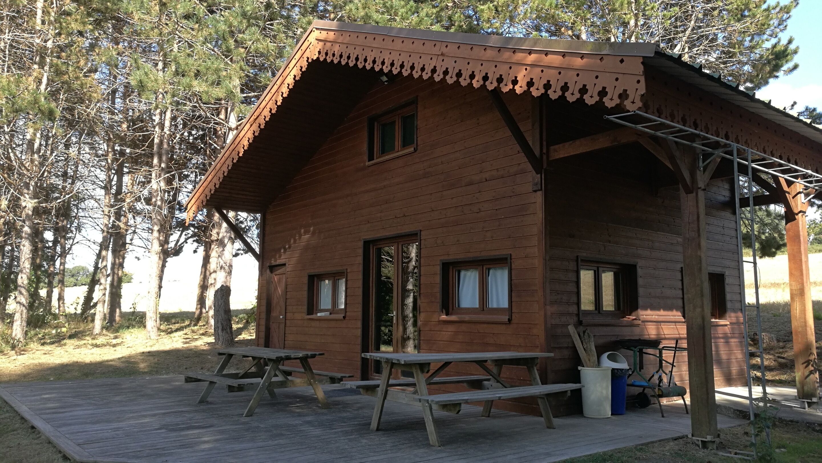A rustic wooden cabin with a porch, two windows, and a door.