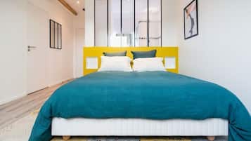 Un dormitorio con una cama, un cabecero amarillo y una puerta blanca.