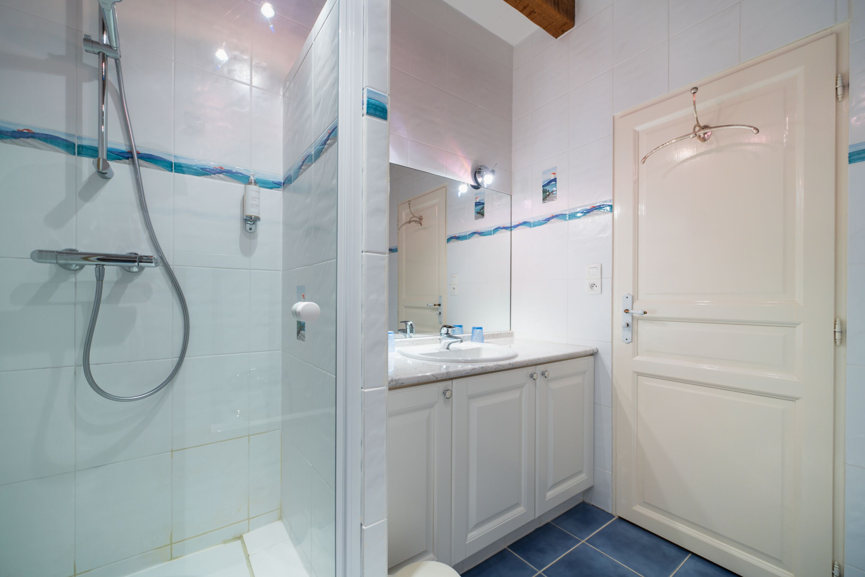 A bathroom with a shower, sink, and toilet.