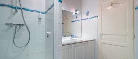 A bathroom with a shower, sink, and toilet.