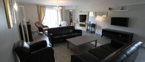 A modern living room with a sofa, coffee table, and TV.