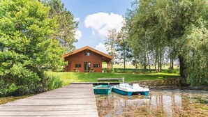 A wooden dock leading to a rustic cabin with a stone wall and a small boat docked nearby. - Domaine de la Poignardiere (Chatillon-sur-Indre)