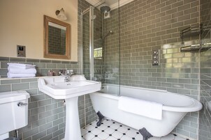 Un baño con lavamanos blanco, bañera y zona de ducha.