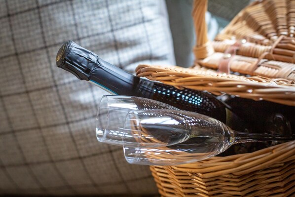 A wicker basket containing a wine bottle and a wine glass. - The Running Horses (Dorking)