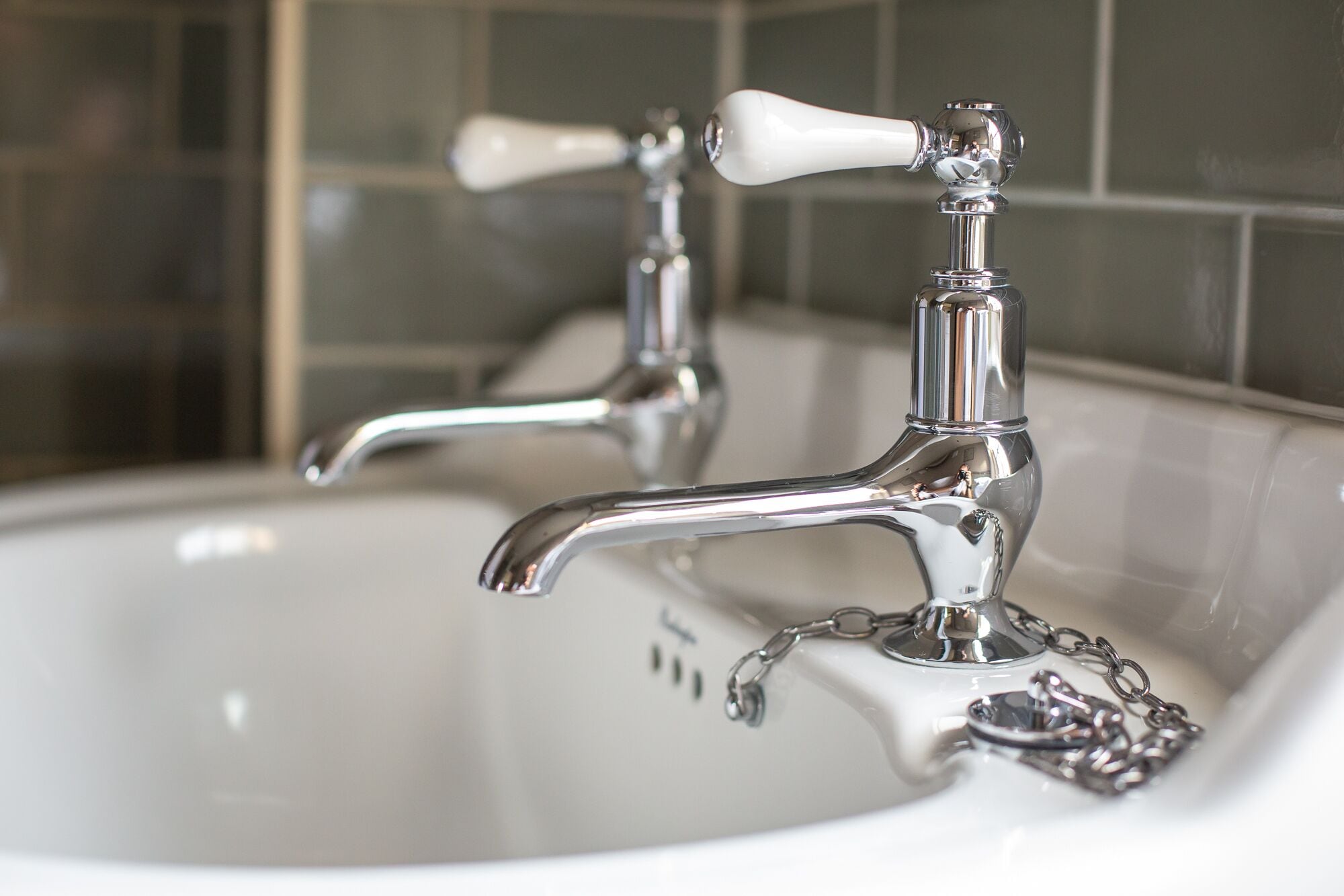 Un lavabo de salle de bain avec un robinet chromé et une poignée blanche.