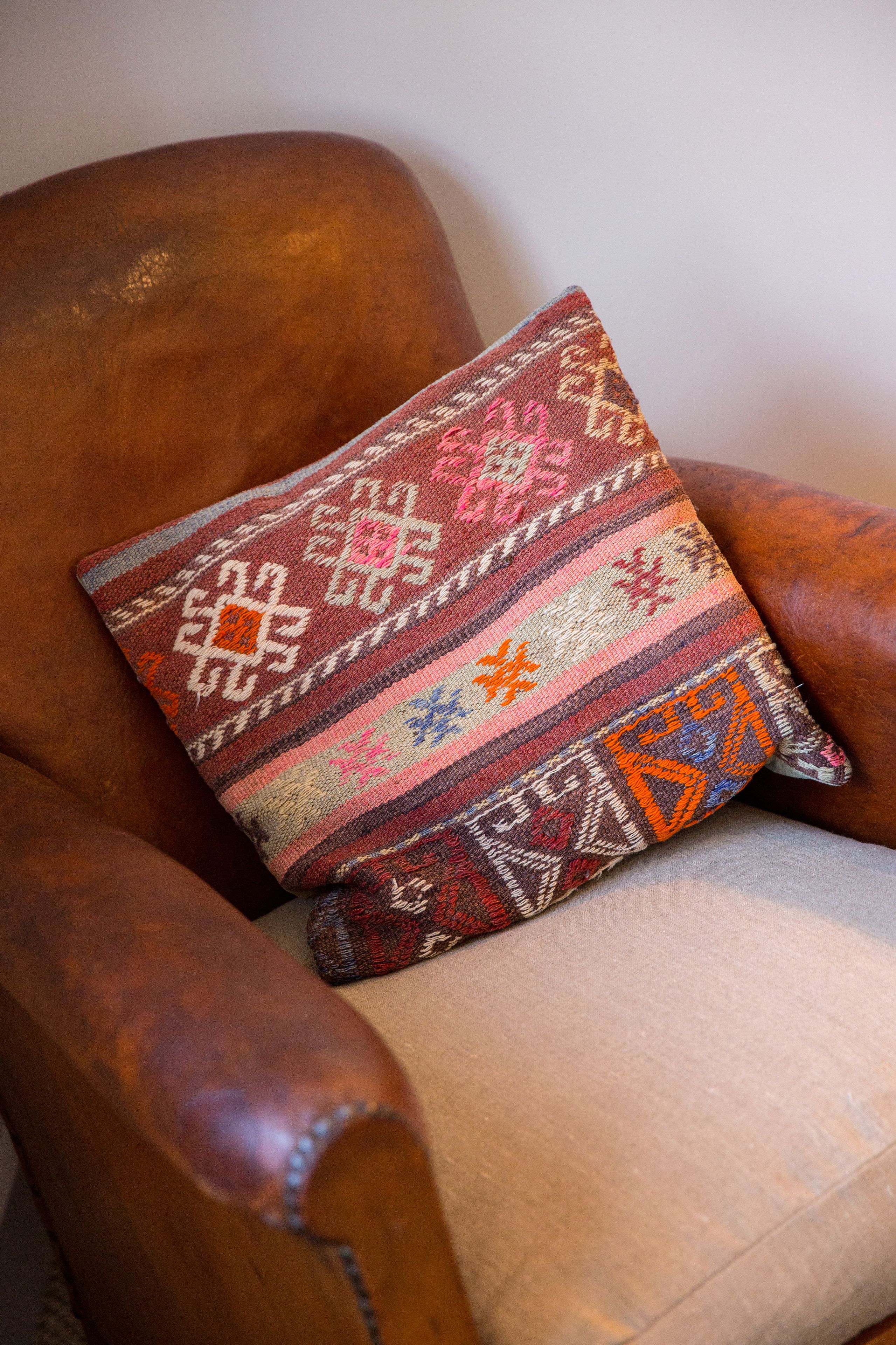 A wooden armchair with a patterned cushion.