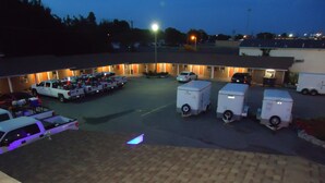 Een parkeerplaats met diverse witte vrachtwagens en een gebouw op de achtergrond.