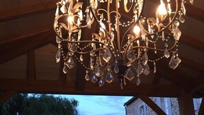 A chandelier with multiple lights and crystal decorations hanging from a wooden ceiling. - La Girarde (Saint-Quentin-de-Caplong)
