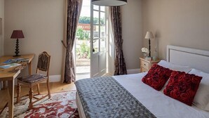 A bedroom with a bed, a desk, a chair, and a window with curtains. - La Girarde (Saint-Quentin-de-Caplong)