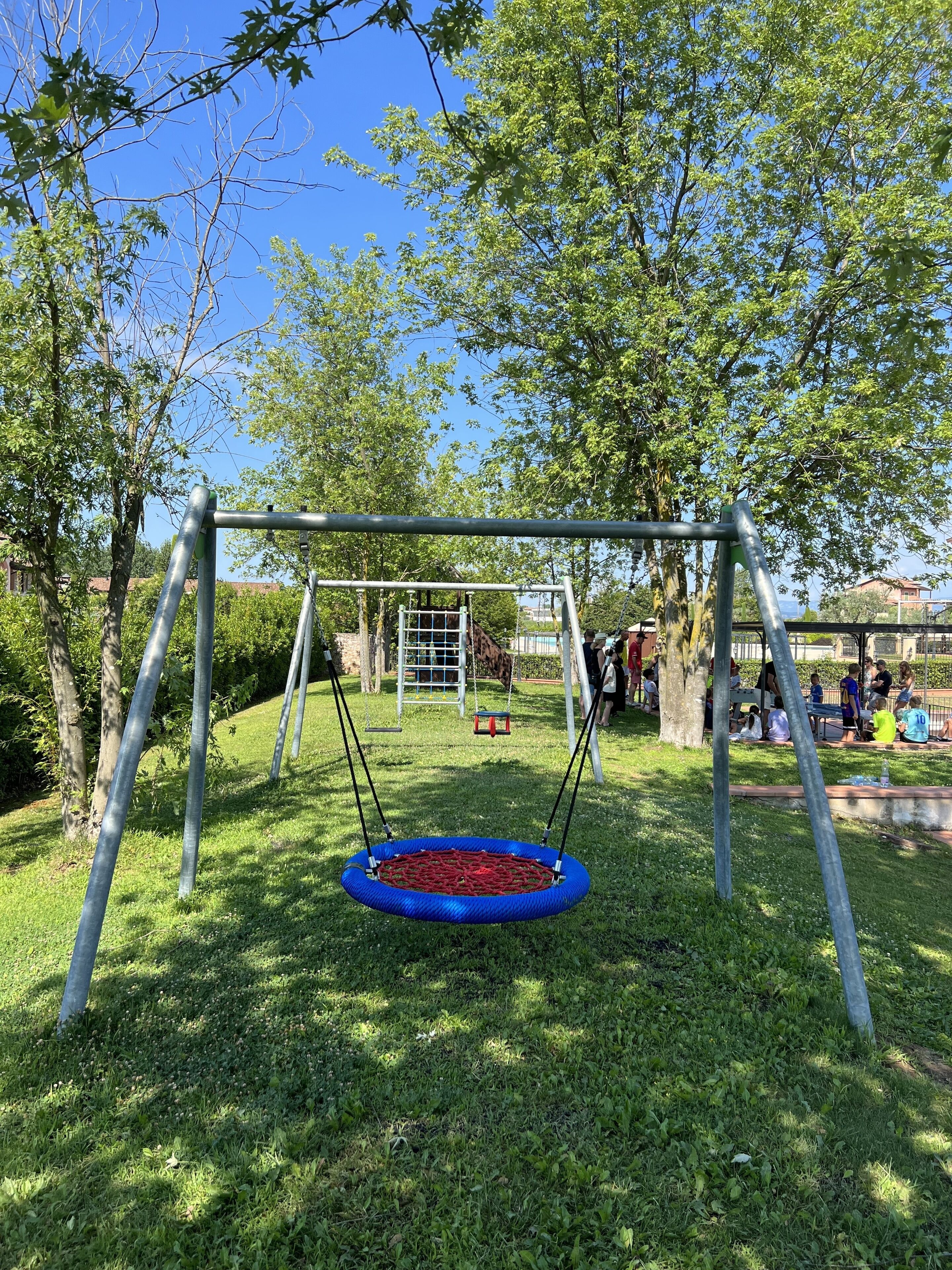 A playground with a swing set and a trampoline.