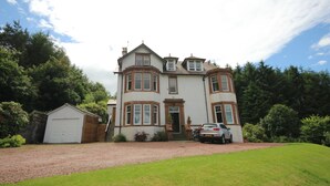 A large, two-story house with a prominent front entrance, a driveway, and a garage. - Braemount House (Paisley)