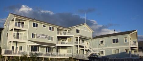 A multi-story hotel with balconies and a waterfront view.