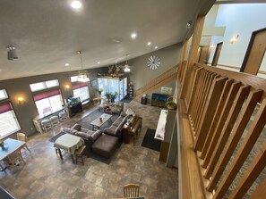 A spacious living area with a high ceiling, a staircase, and a view of the outside. - SunRise Inn Hotel (Mondovi)