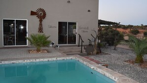 Un edificio moderno con piscina, una decoración con molino de viento y un cartel que dice 'Farmall Welcome'.