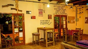 A cozy, rustic bar with wooden furniture, a Coca-Cola sign, and a 'Free Beer Tomorrow' poster.