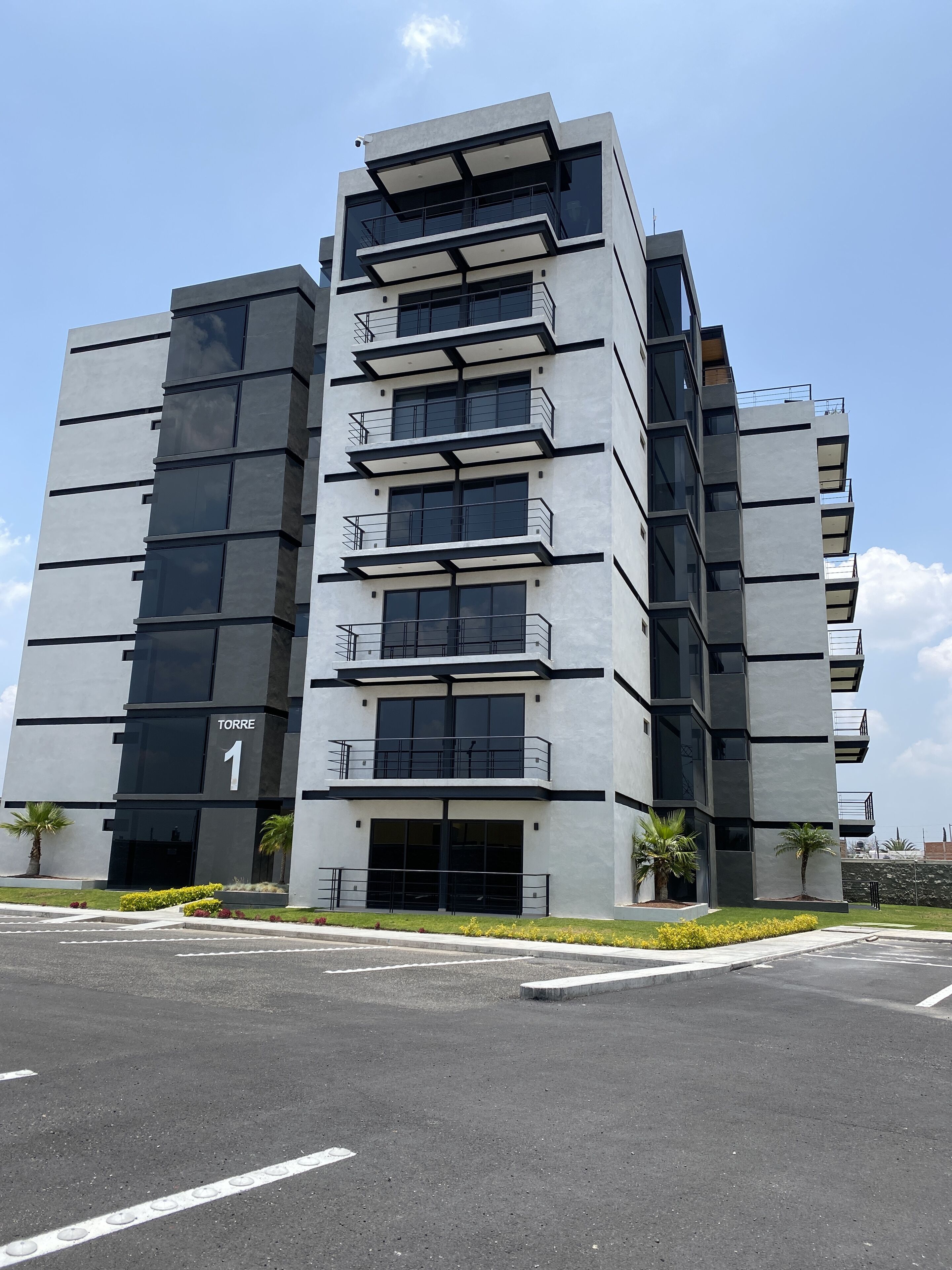 Un edificio moderno de varios pisos con balcones y ventanas amplias.