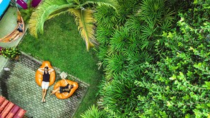 A rooftop garden with two orange bean bags, a hammock, and lush greenery. - The Pelican Larry Hostel (Cali)
