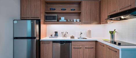 A modern kitchen with wooden cabinets, stainless steel appliances, and a white countertop.