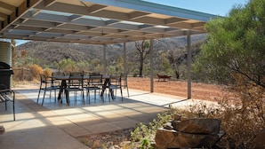 An outdoor patio with a covered seating area, a table, and chairs. - Arkaroola Wilderness Sanctuary (Arkaroola Village)