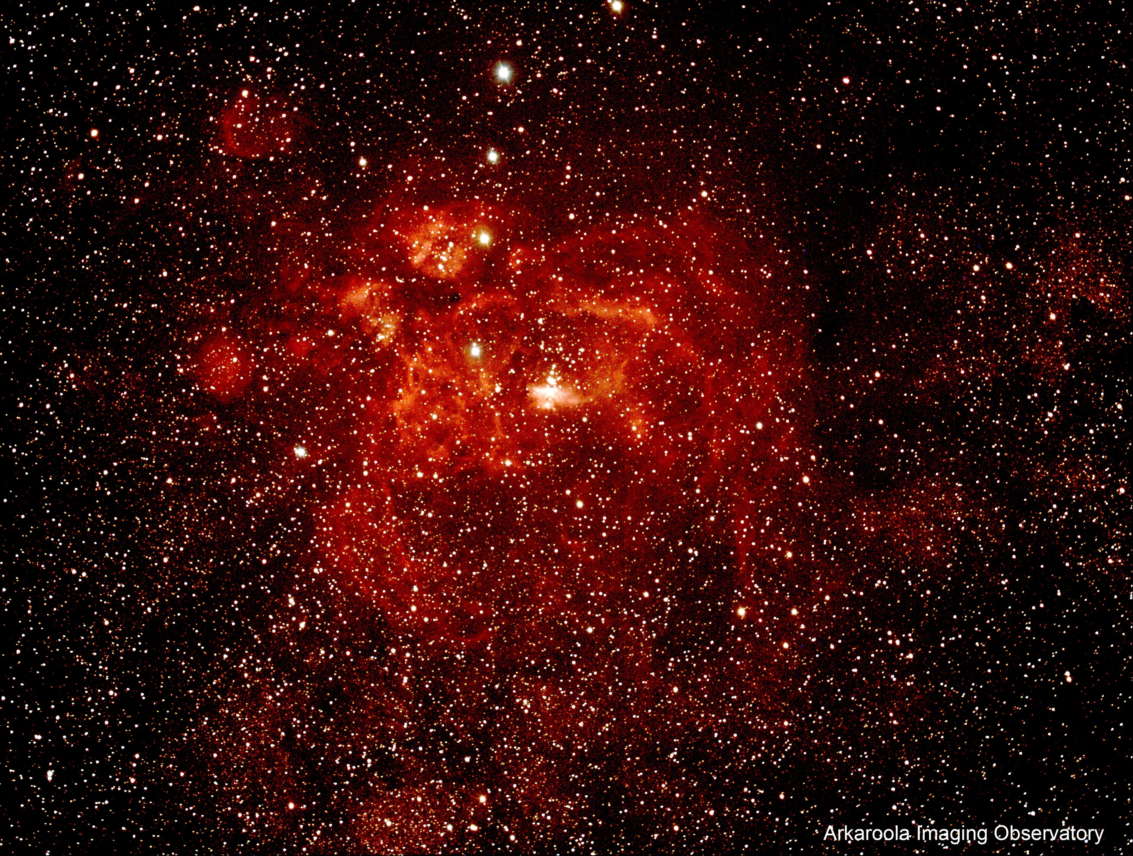A dense cluster of stars and nebulae in space.