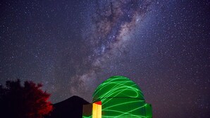 A building with a dome-shaped structure illuminated with green lights against a starry night sky. - Arkaroola Wilderness Sanctuary (Arkaroola Village)