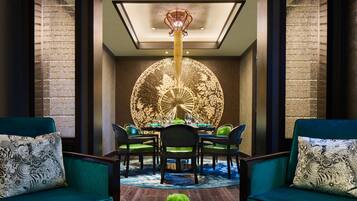 A dining area with a round table, chairs, and a chandelier.