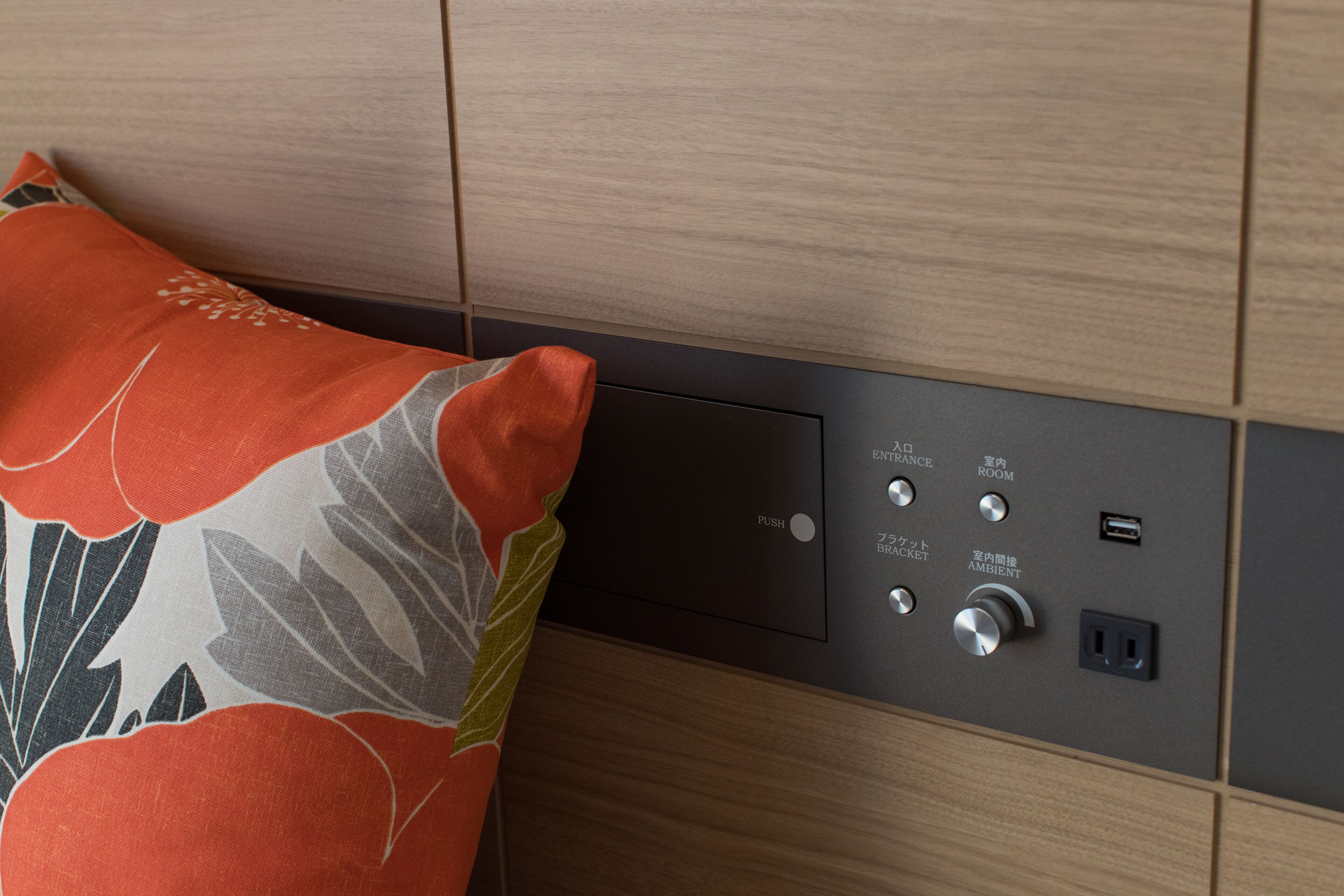 Un panel de control con botones etiquetados como 'Entrada', 'Habitación', 'Empujar' y 'Ambiente' en una pared.