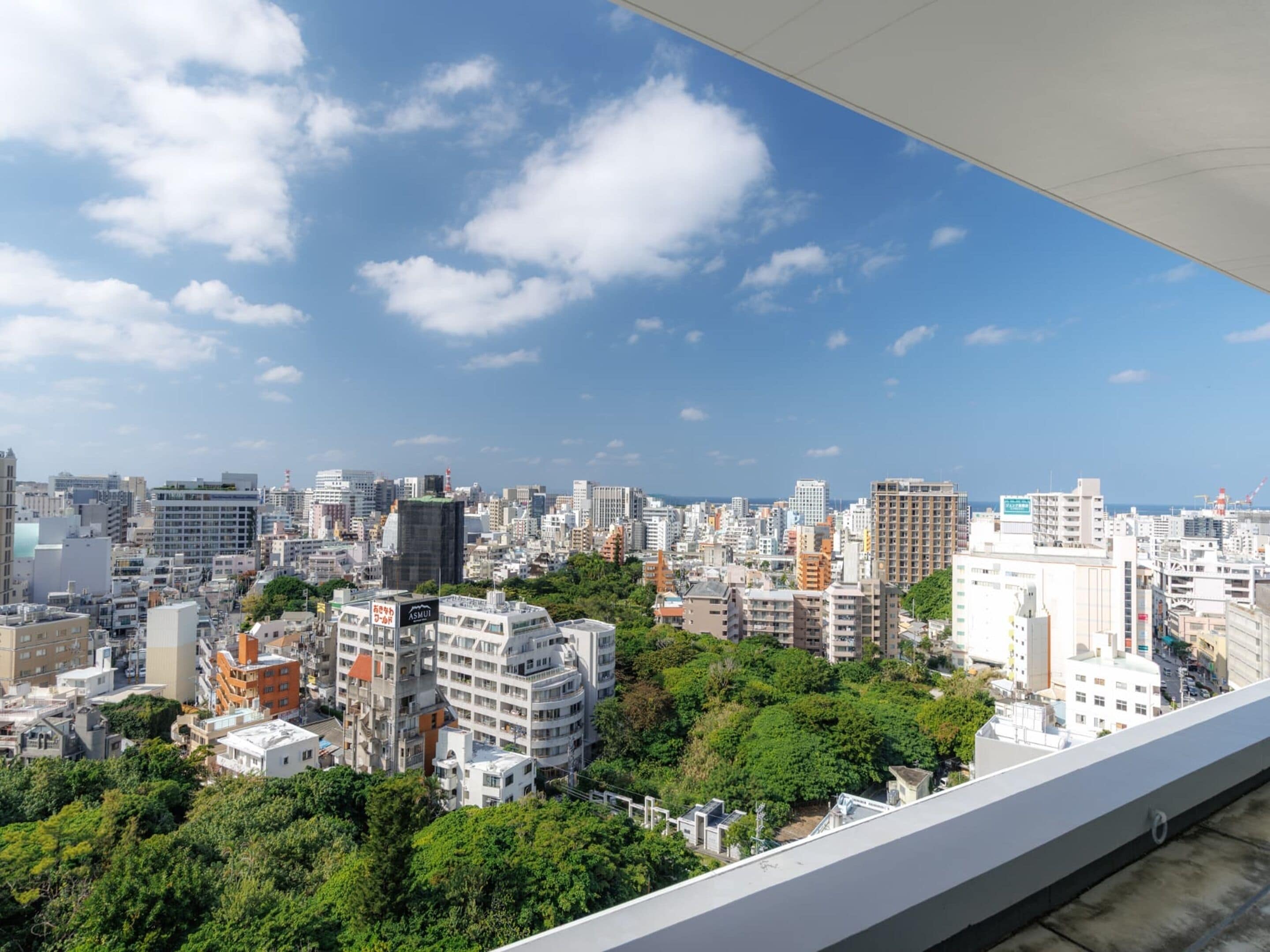 A cityscape with a variety of buildings, including high-rise apartments and commercial structures, under a clear blue sky.