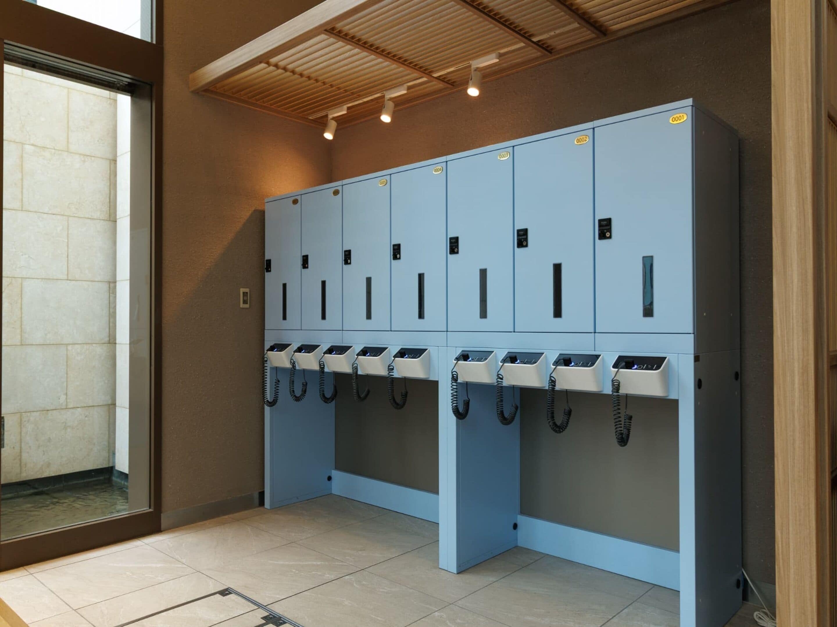 A row of blue lockers with individual compartments, each with a lock and a keyhole.