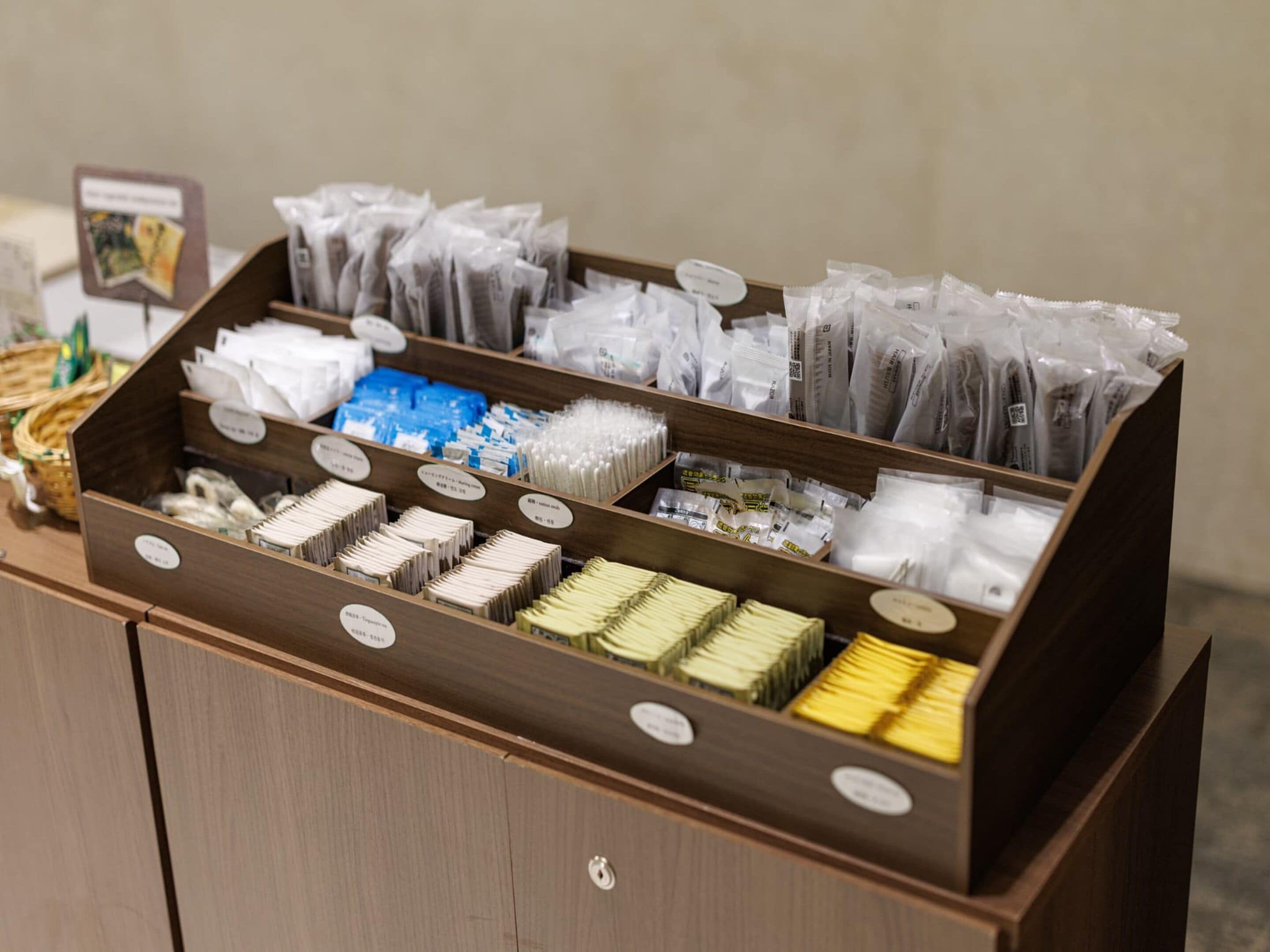 A wooden display case with various packaged items, including what appears to be food products and possibly toiletries, organized in multiple compartments.