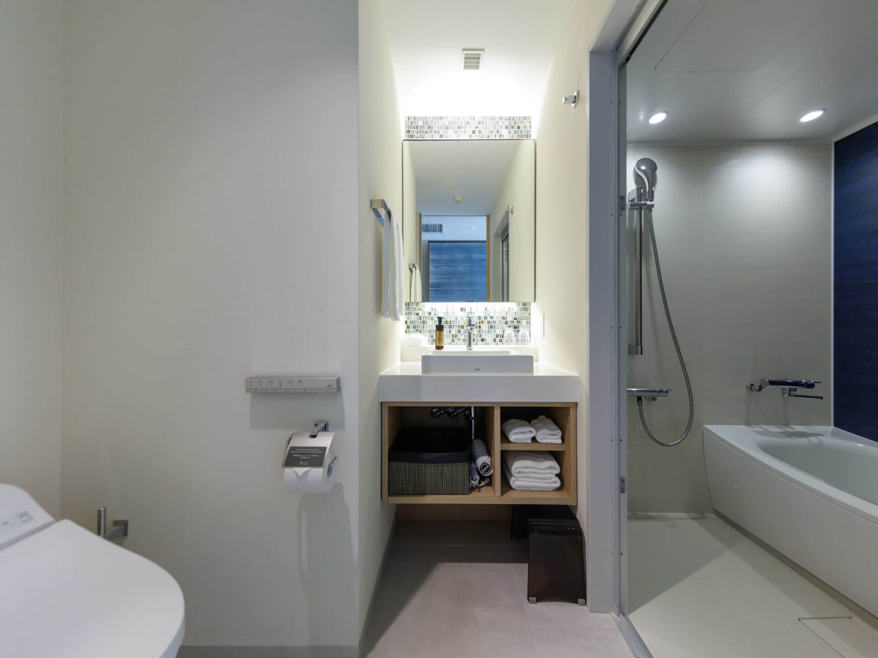 A modern bathroom with a toilet, sink, and shower.