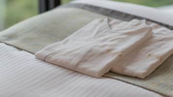 A neatly folded towel with the word "Blossom" embroidered on it, placed on a bed with a striped pattern.